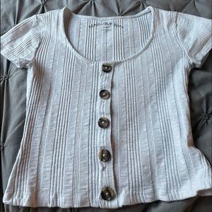 A white crop top with buttons all down the front.